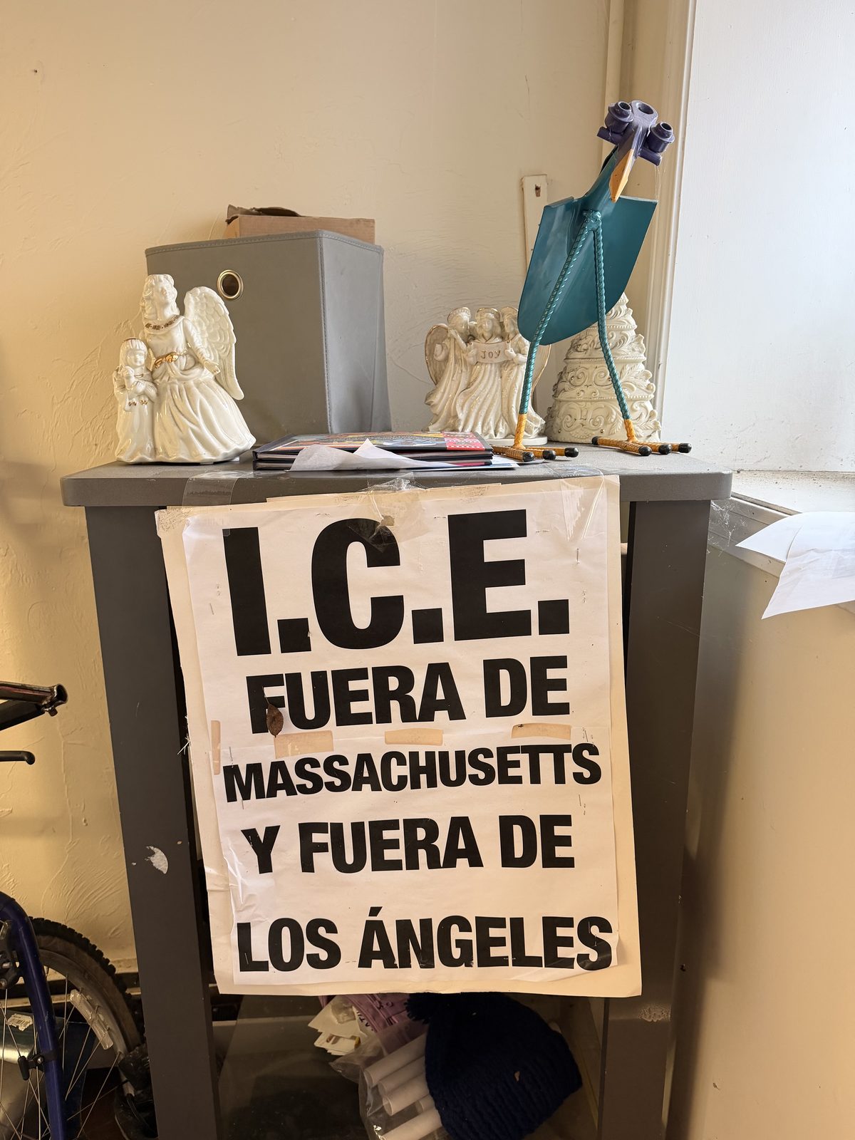 Bilingual immigration advocacy sign and handmade objects by an office window
